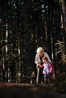 mormor och henne autistisk stor dotter njuter Semester tillsammans utomhus, liggande på grön gräs på filt och leende till kamera. fritid familj livsstil, lycka och ögonblick. foto