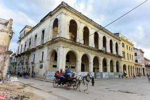 Havanna, kuba - jan 8, 2017 - häst vagn godkänd gammal byggnad i de bearbeta av kollaps i de gammal havana grannskap av Havanna, kuba. foto