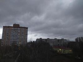 mörk moln på gryning över de stad foto