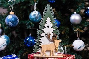 trä- stickat älg. söt älg. leksak mot de bakgrund av en ny år krans, stickat hare och älg på en jul träd foto