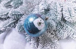 kreativ diy hantverk hobby. framställning handgjort hantverk jul ornament och bollar med känt gran träd. jul träd med färgrik bollar och gåva lådor över vit tegel vägg med blå och vit bollar