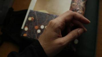 närbild av en kvinnas hand på en bok i en dyster miljö foto