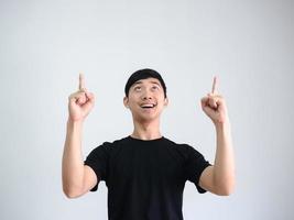 asiatisk man glad punkt dubbel- finger och titta inh upp på vit bakgrund foto