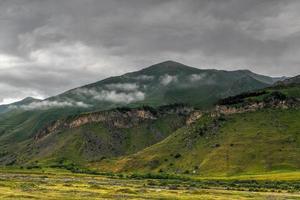 kuperad landskap nära de by av gergeti i georgien, under montera kazbegi. foto