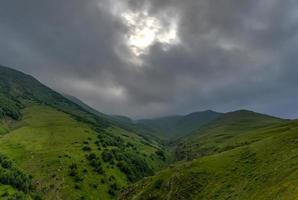 kuperad landskap nära de by av gergeti i georgien, under montera kazbegi. foto