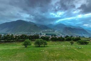 kuperad landskap nära de by av gergeti i georgien, under montera kazbegi. foto