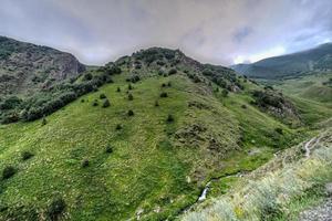 kuperad landskap nära de by av gergeti i georgien, under montera kazbegi. foto
