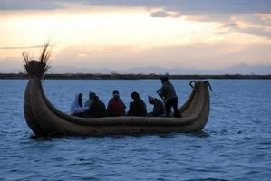 ryttare i en vass båt runt om sjö titicaca, peru foto