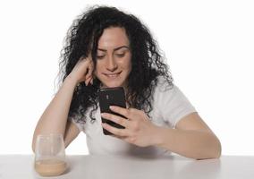 porträtt av en Lycklig kvinna använder sig av mobil telefon isolerat över vit bakgrund foto