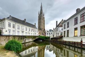 kanaler av Brugge, belgien med de kyrka av vår lady i de bakgrund foto