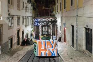 årgång känd bica spårväg på natt med graffiti i Lissabon, portugal. foto