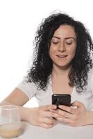 porträtt av en Lycklig kvinna använder sig av mobil telefon isolerat över vit bakgrund foto