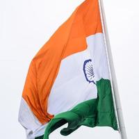 Indien flagga vajar högt på connaught plats med stolthet över blå himmel, Indien flagga vajar, indiska flaggan på självständighetsdagen och republikens dag i Indien, tilt up shot, viftande indiska flaggan, har ghar tiranga foto