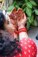 skön kvinna klädd upp som indisk tradition med henna mehndi design på henne både händer till fira stor festival av karwa chauth, karwa kauth fester förbi indisk kvinna för henne Make foto