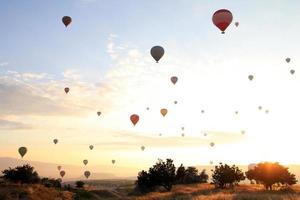 resa till goreme, Kappadokien, Kalkon. de soluppgång i de bergen med en massa av luft varm ballonger i de himmel. foto