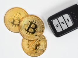 närbild tre gyllene bitcoins med bil avlägsen vit bakgrund foto