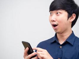 asiatisk man glad känsla Lycklig innehav mobil telefon ser på Plats vit bakgrund foto
