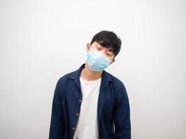 asiatisk man med skydda mask sjuk och stänga ögon känna dålig på vit bakgrund foto