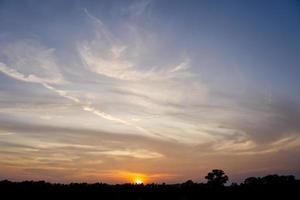 gul himmel moln från de solens strålar är handla om till set, fotografera av de solnedgång i de landsbygden i de kväll foto