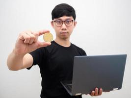 asiatisk man med glasögon innehav bitcoin och bärbar dator på vit bakgrund foto