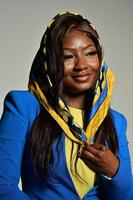 ung skön afrikansk amerikan mode modell med traditionell afrikansk stil scarf Framställ på grå bakgrund foto