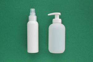 vit omärkt plast dispenser pump och spray flaska på grön bakgrund med kopia Plats. kosmetisk paket mockup, flytande tvål flacon, hand desinfektionsmedel utan märka, schampo organisk spa, dusch gel foto