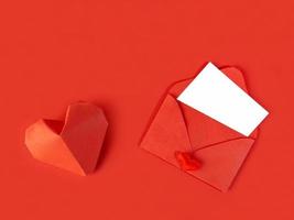 röd papper kuvert med en notera för hjärtans dag på en vit bakgrund med hjärtan foto