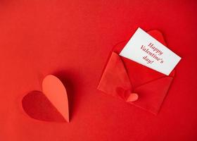 röd papper kuvert med en notera för hjärtans dag på en vit bakgrund med hjärtan foto
