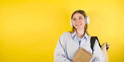 Lycklig kvinna studerande lyssnar till musik eller podcast innehav bärbar dator. utbildning begrepp. studio porträtt baner med copy foto