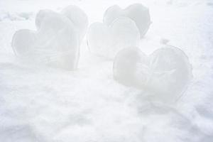 många hjärtan - en symbol av kärlek, tillverkad av is, stå i en snödriva. hjärtans dag. romantisk begrepp. foto