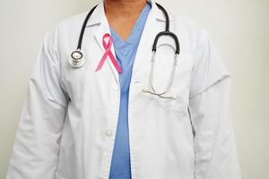 asiatisk kvinna läkare med rosa band, värld bröst cancer dag på oktober. foto