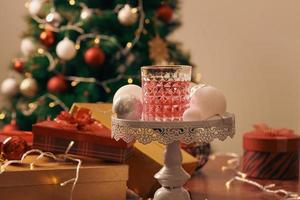 dekorerad jul träd med färgrik bollar och gåva lådor på Hem foto