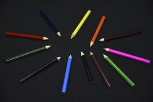 färgad pennor på en svart bakgrund. små pennor närbild. foto