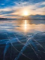vinter- frostig solig dag på en sjö med transparent mörk blå is. foto