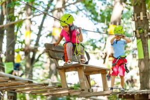äventyr klättrande hög tråd parkera - barn på kurs rep parkera i berg hjälm och säkerhet Utrustning foto
