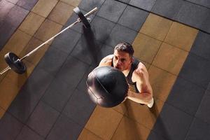 stark man i sportigt kläder spelar basketboll i de Gym foto