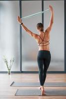 bak- se. ung kvinna i sportigt ha på sig och med smal kropp ha kondition yoga dag inomhus foto