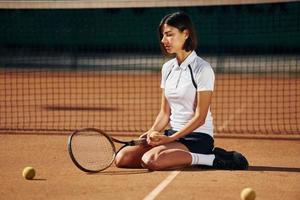 på de jord. kvinna tennis spelare är på de domstol på dagtid foto