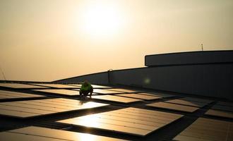 tekniker förse kvartals sol- cell underhåll tjänster på de fabrik tak foto