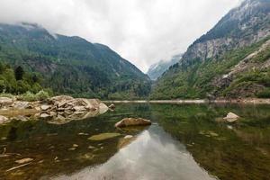 alpina hög berg sjö, barr- trän är reflekterad i de vatten, antrona dal campliccioli sjö, Italien piedmont foto