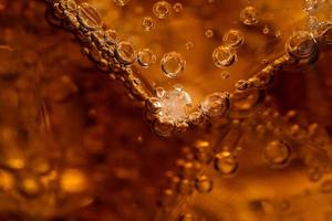 stänga upp cola med is och bubblor i glas. is kuber i cola dryck. foto