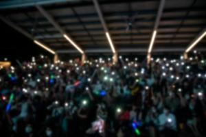 människor innehav cigarett tändare och mobil smartphones på en konsert foto