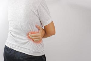 kvinna lidande från midja, ryggvärk eller höft smärta på vit bakgrund. ryggvärk, kontor syndrom och hälsa begrepp. foto