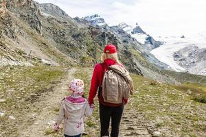 vandring - vandrare kvinna på vandra med ryggsäck levande friska aktiva livsstil. vandrare flicka gående på vandra i berg natur landskap i swiss alperna, schweiz. foto