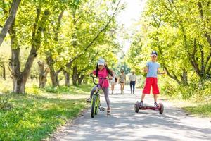 flicka på en cykel och en pojke på en gyroskop är ridning tillsammans foto