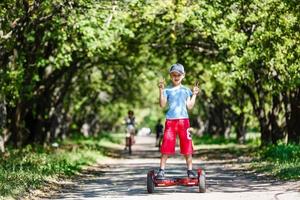 flicka på en cykel och en pojke på en gyroskop är ridning tillsammans foto