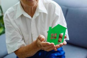 senior kvinna innehar de layout av de hus i henne händer foto