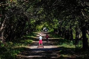 flicka på en cykel och en pojke på en gyroskop är ridning tillsammans foto