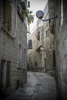 smal gator och sten väggar av de gammal stad av jerusalem foto