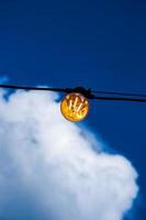 stänga upp av ett edison-stil tråd på en ljus Glödlampa mot en molnig himmel. energi kris. foto